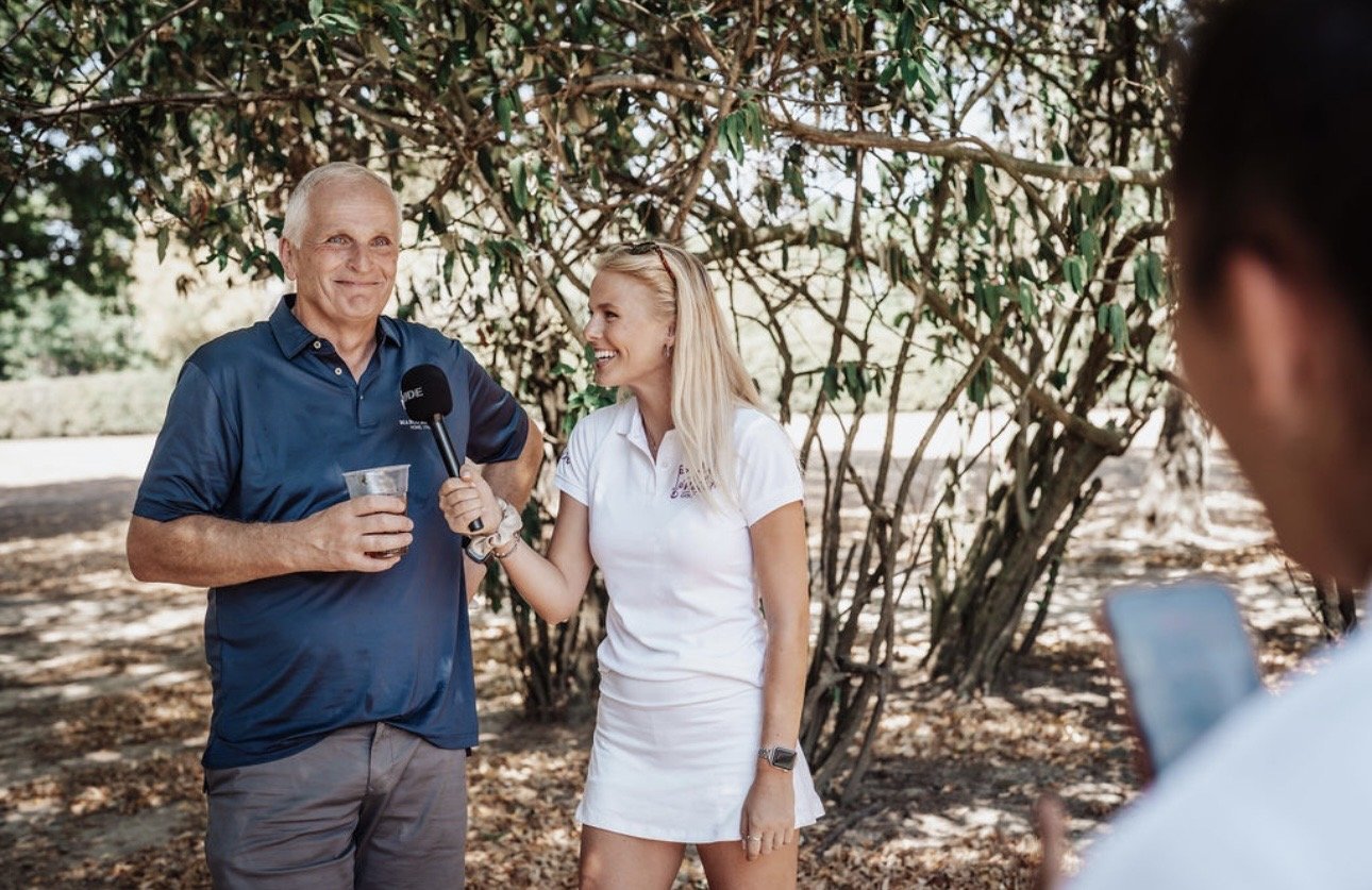 Hannah White interviewing a guest at a charity golf day