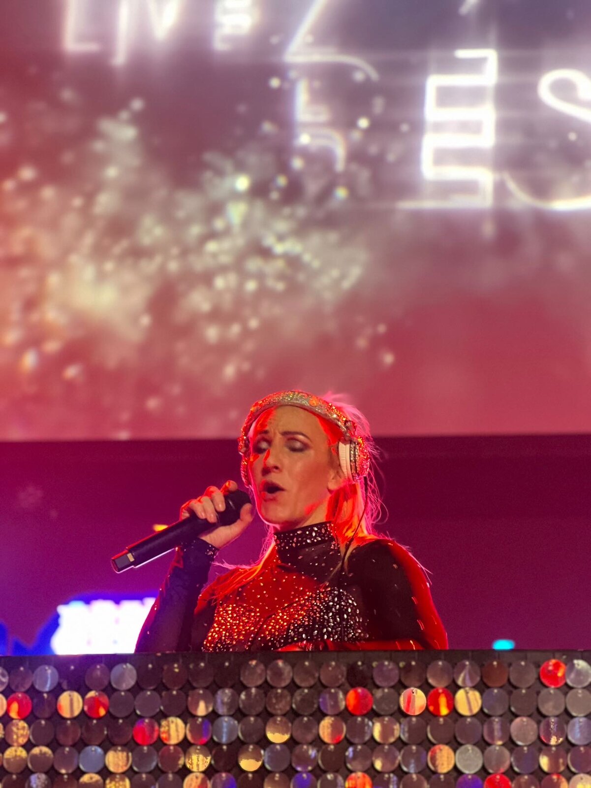 Sarah Giggle performing live on stage with headphones